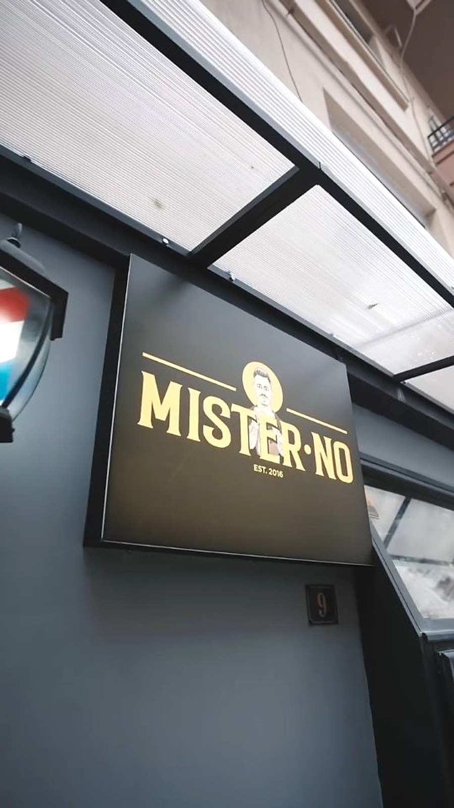 Η βιτρίνα του Mister No Barber Crew στην Ισαύρων 9, με τη χρυσή επιγραφή